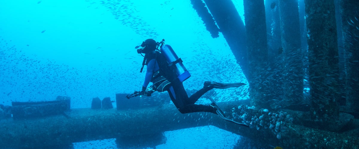 Scuba diver floating in deep ocean water, illustrating the extreme underwater conditions relevant to deep-sea motor technology